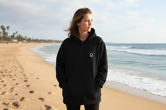 The Default Was Never Mandatory oversized graphic hoodie in black, front view showing small white No 925 baseline glyph on left chest, relaxed oversized fit with pouch pocket.
