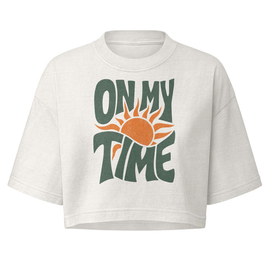 On My Time garment dye cropped tee with ON MY TIME in dark green retro lettering wrapped around an orange rising sun
