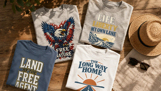 Flat-lay of No 925 freedom lifestyle graphic tees on sunlit wood with a woven hat and sunglasses