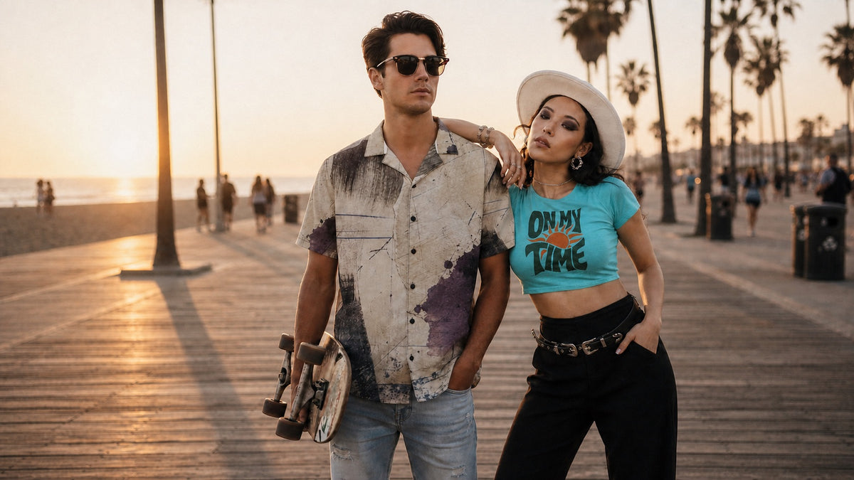 Two friends on a beach boardwalk at sunset, one holding a skateboard and one wearing a No 925 On My Time crop tee