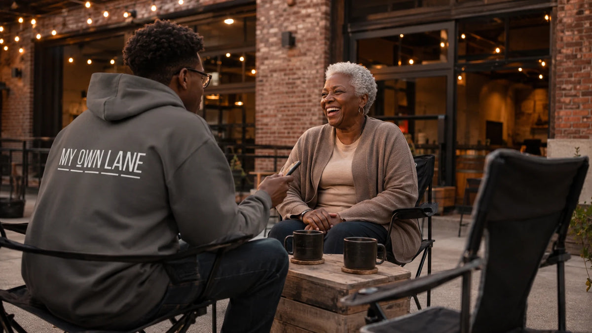 Interviewer in a My Own Lane hoodie talking with a laughing woman outside a brick taproom