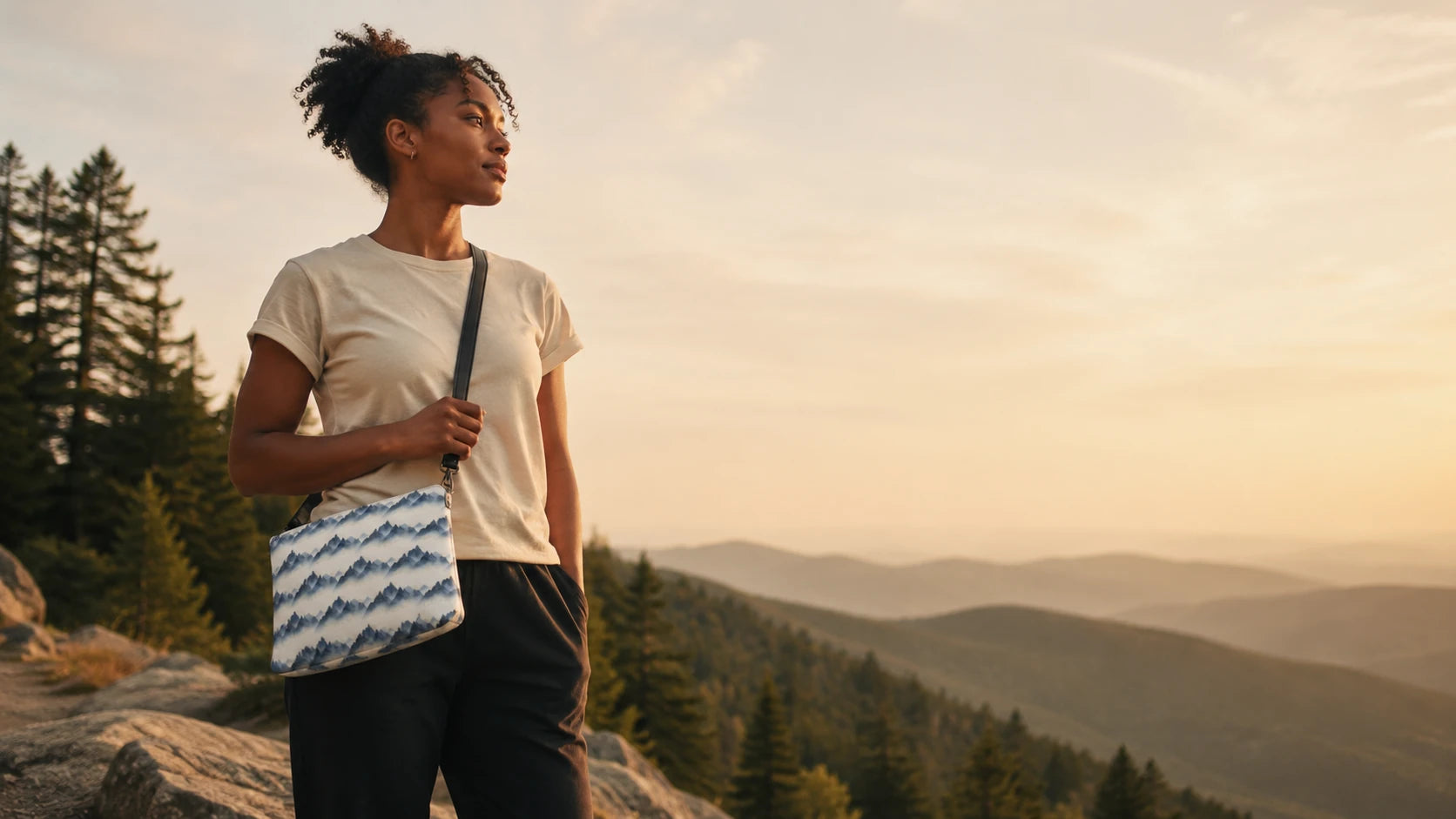 Woman at a mountain overlook wearing the NO.925 Geometric Mountain all-over-print crossbody bag