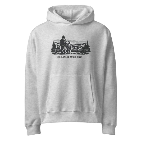 Parent and child at a fence looking over a mountain road, The Lane Is Yours Now oversized graphic hoodie