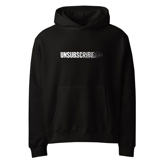 Unsubscribe wordmark dissolving into pixels on a black oversized graphic hoodie
