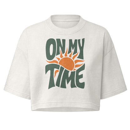 On My Time garment dye cropped tee with ON MY TIME in dark green retro lettering wrapped around an orange rising sun