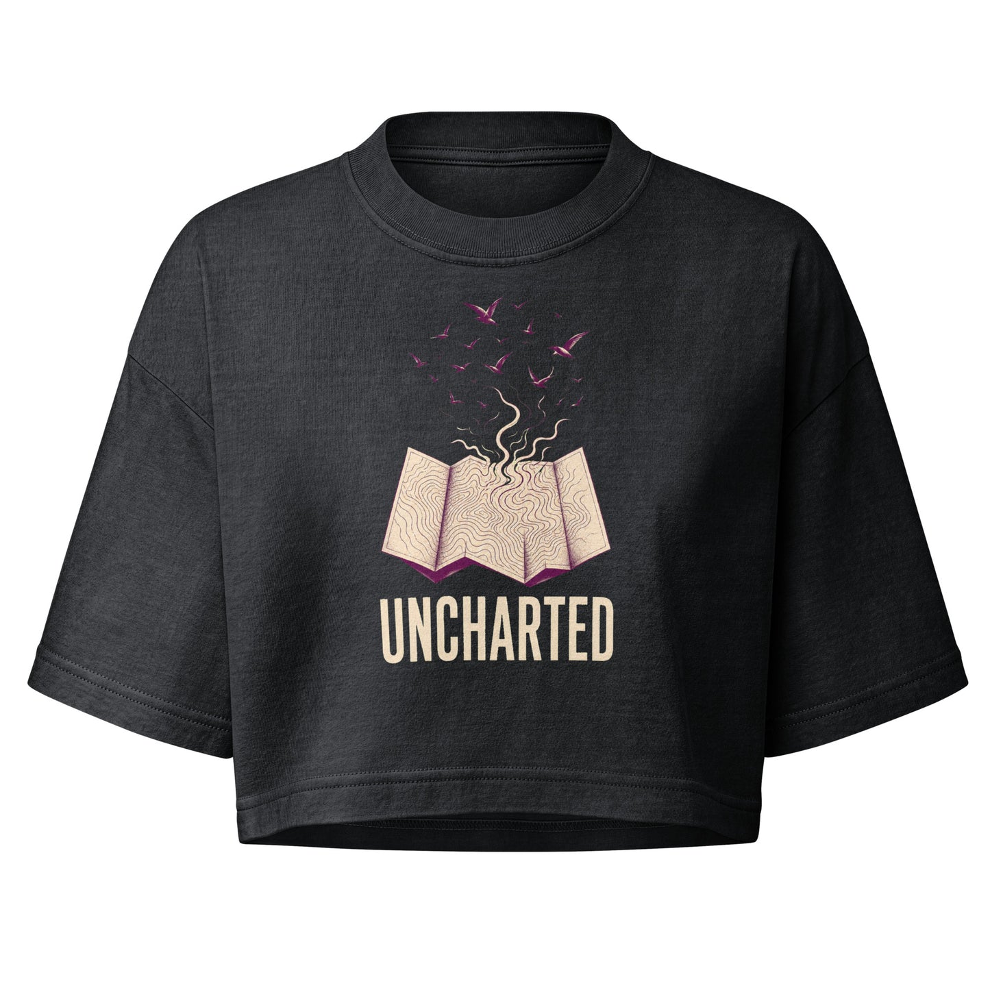 Uncharted garment dye cropped tee in faded black with a cream topographic map opening and purple birds rising above the word UNCHARTED